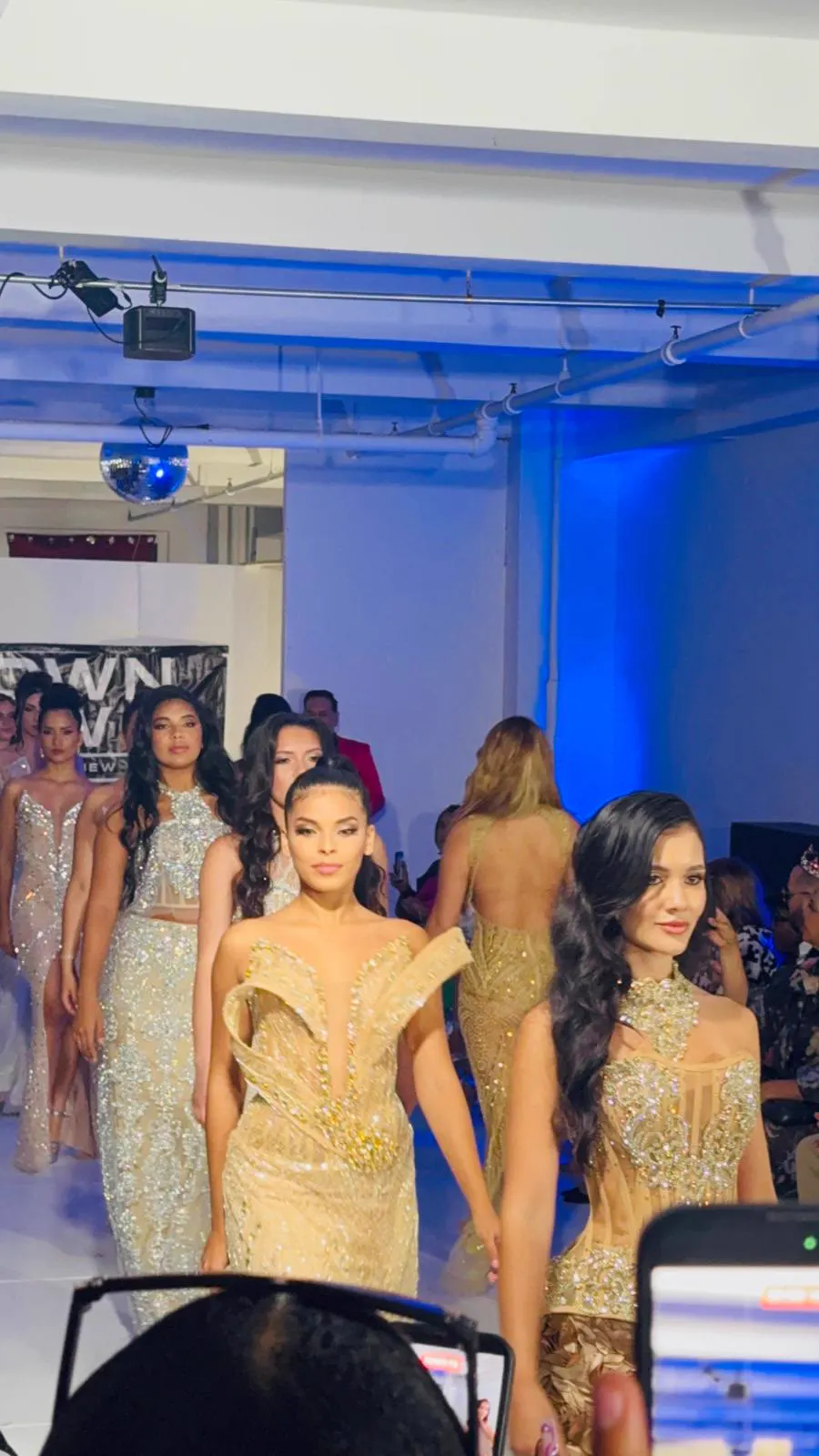 Models in gold gowns walking the runway
